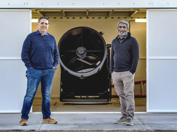 Robert Furfaro and Vishnu Reddy standing next to machine